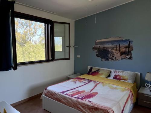 1 dormitorio con cama con chanclas en Casa EleGiò - Blue Village 2 en Marina di Pisticci