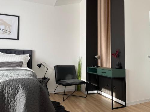 a bedroom with a bed and a desk and a chair at Studio apartman Mia in Županja