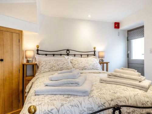 1 dormitorio con 1 cama con toallas en Piggledy Cross Barn, en Butterton