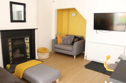 a living room with a couch and a fireplace at Central Worthing, 3 bedrooms, 600m from beach in Broadwater
