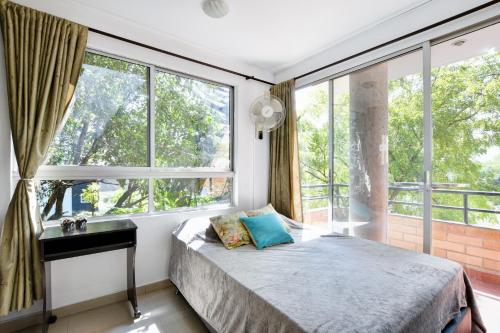 a bedroom with a bed and large windows at International House Co-Living in Medellín