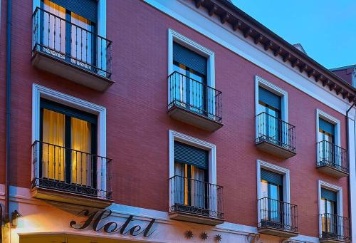 a red building with balconies on the side of it at Hotel Las Cabañas in Peñaranda de Bracamonte