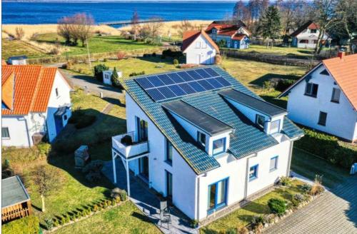 uma casa com painéis solares por cima em Bodden-Adler em Fuhlendorf