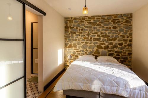 a bedroom with a stone wall and a bed at Villa Basse Cour in Durbuy