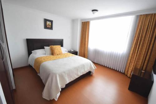 a bedroom with a bed and a large window at HOTEL ZAFIRO PLAZA in Tunja