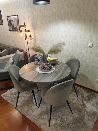 a dining room table with chairs and a bowl of food on it at NOVAK apartman in Vrnjačka Banja