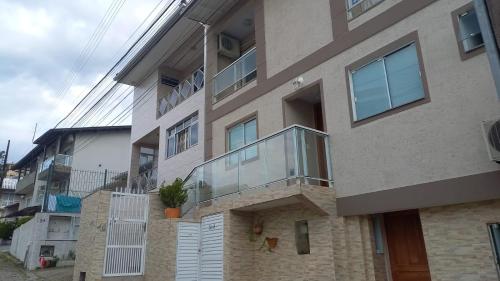 a building with a glass balcony on the side of it at AP Floripa in Florianópolis