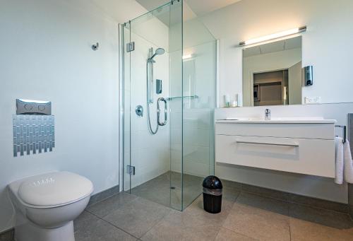 W łazience znajduje się toaleta, umywalka i prysznic. w obiekcie Pukekura Motor Lodge w mieście New Plymouth