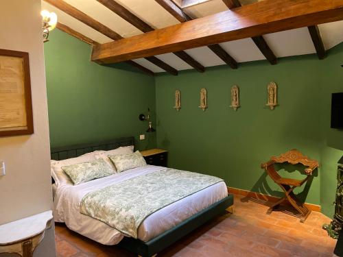 - une chambre avec un lit et un mur vert dans l'établissement Borgogna 14, à Reggio d'Émilie