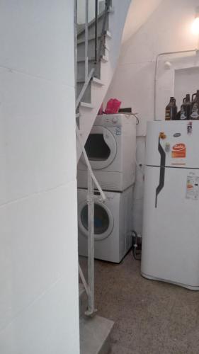 a laundry room with a washing machine and a refrigerator at Hostel Juniors in Buenos Aires