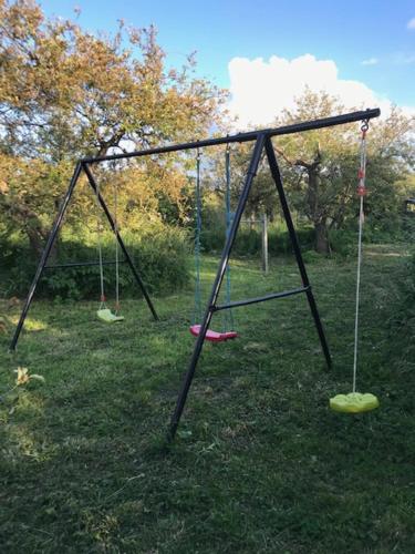 an empty swing set in a field of grass at Bed en Breakfast In het Fruit in Zuidoostbeemster