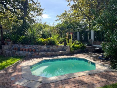 a swimming pool in a yard with a brick patio at Matshana Lodge in Hermanus