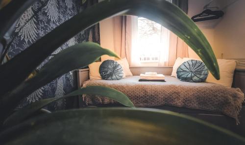 a bedroom with a bed with pillows and a plant at Whole Stylish Apartment 1880s Guinness Worker House in Dublin