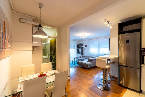 kuchnia i salon ze szklanym stołem i krzesłami w obiekcie Flexible SelfCheckIns 40 - Zagreb - Parking - Big Loggia - New - 2 beedroms w Zagrzebiu