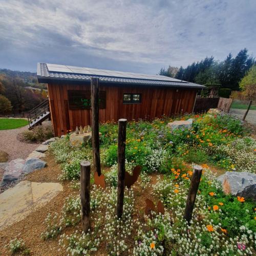 a garden in front of a wooden cabin at LAC ABANE AU LAC in Butgenbach