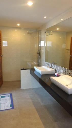 a bathroom with two sinks and a large mirror at Tropical Sea View Residence in Lamai