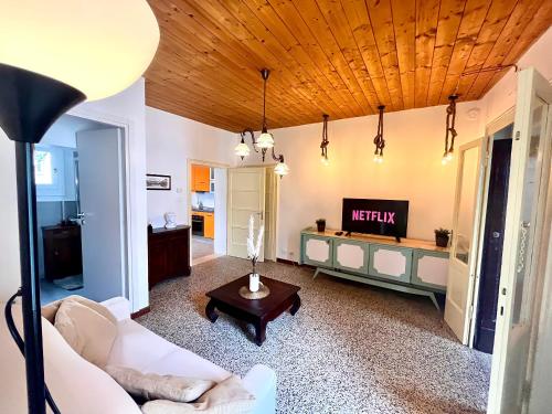 a living room with a white couch and a tv at [Piazza Vittoria] Historic Netflix penthouse in Brescia