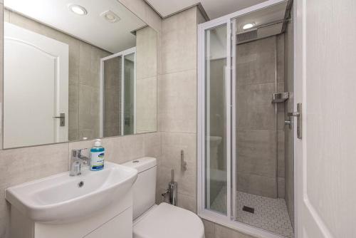 a bathroom with a toilet and a sink and a shower at Blouberg Pearl in Cape Town