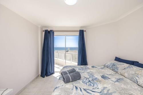 a bedroom with a bed and a view of the ocean at Blouberg Pearl in Cape Town