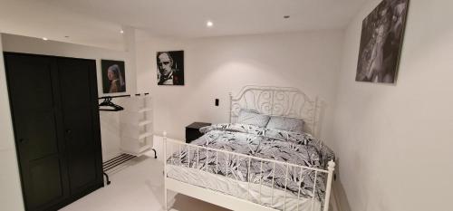 - un lit blanc dans une chambre blanche avec des photos sur le mur dans l'établissement Luise Hollywood, à Bruxelles