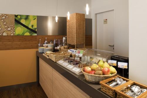 a buffet with apples and baskets of food on a counter at ibis Bamberg Altstadt in Bamberg