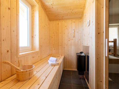 una sauna de madera con bañera y ventana en Chalet Arber in St Englmar with its own HotTube, en Sankt Englmar