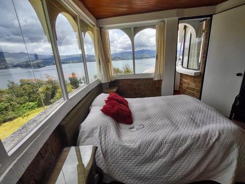 a bedroom with a bed in a room with windows at Refugio Génesis habitaciones Lago de Tota in Tota