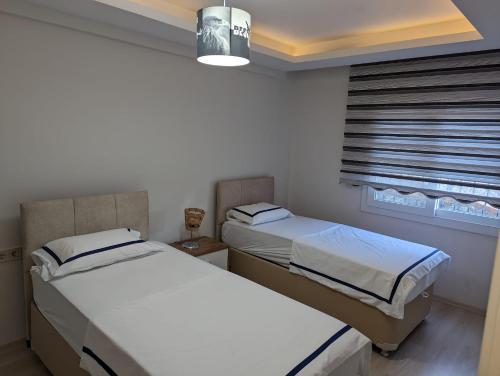 two beds in a small room with a window at Vista Panorama Sunshine in Kusadası