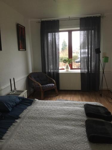 a bedroom with a bed and a window with a chair at Motel Villa Søndervang twin room in Harndrup