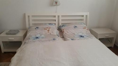 Una cama blanca con dos almohadas encima. en Kuća za odmor Jovanović en Perućac
