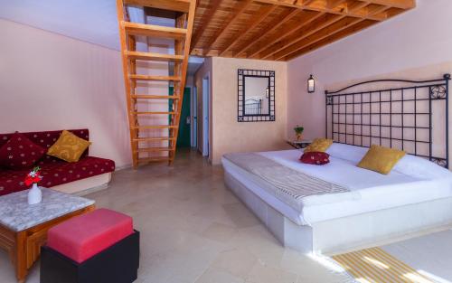 フーム・スークにあるLe Petit Palais Djerba & Spaのベッドルーム1室(ベッド1台、はしご、ソファ付)