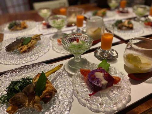 a table with plates of food and glasses of wine at Azumino Salon in Azumino