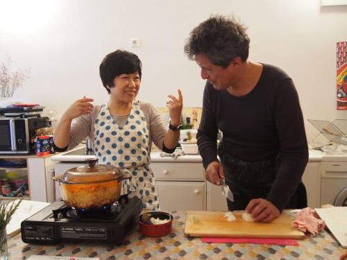 a man and woman standing in a kitchen preparing food at Azumino Salon in Azumino