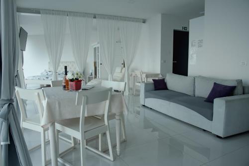 a white living room with a table and a couch at VILA MOLET KOPER in Koper