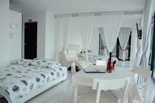 a white bedroom with a bed and a table at VILA MOLET KOPER in Koper