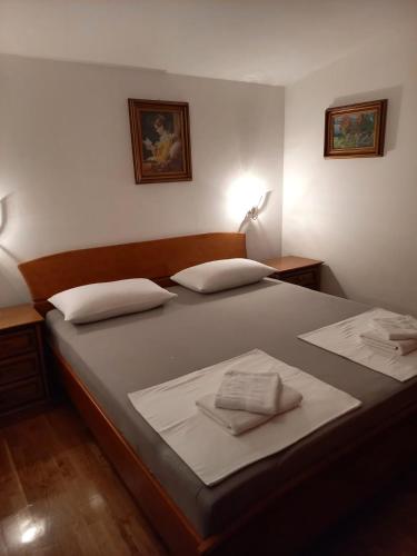 a bedroom with a large bed with two pillows on it at Apartments Raos in Stobreč