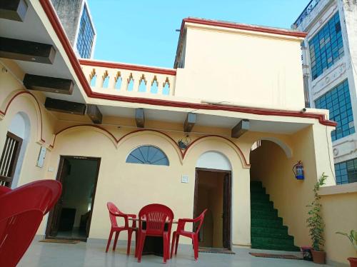 a house with red chairs and a table in front of it at Foreigners Inn in Varanasi