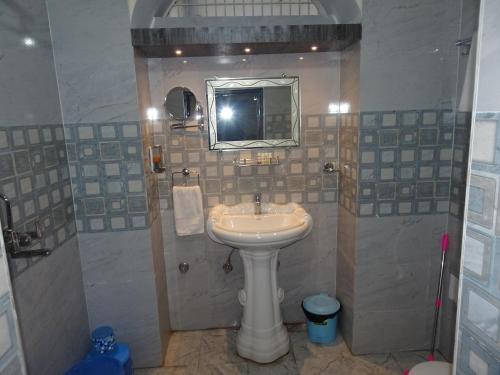 a bathroom with a sink and a mirror at Foreigners' Inn in Varanasi