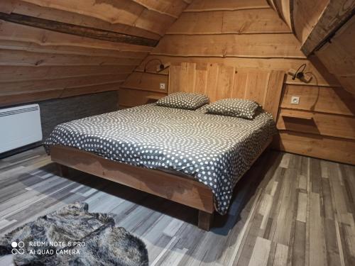 een slaapkamer met een bed in een houten hut bij Appart Chalet hyper centre in Cauterets