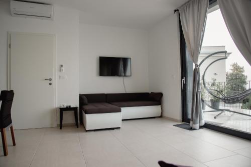 a living room with a couch and a tv at VILA MOLET KOPER in Koper