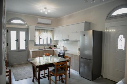 a kitchen with a table and a stainless steel refrigerator at Estia in Kalymnos