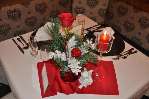 a white table with a candle and flowers on it at Hotel Meida in Pozza di Fassa