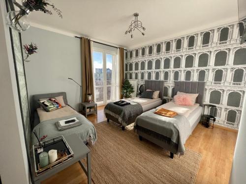 a bedroom with two beds and a couch at Słoneczny Apartament Koszykowy! in Warsaw