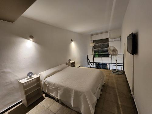 a small bedroom with a bed and a television at Departamento Loft VCP in Villa Carlos Paz