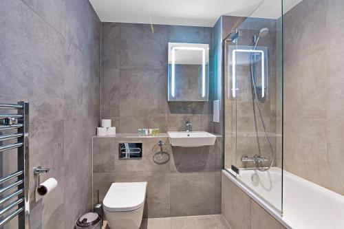 a bathroom with a toilet and a sink and a shower at SPACIOUS, BRIGHT & Modern 1 & 2 bed Apartments at Sligo House - CENTRAL Watford in Watford