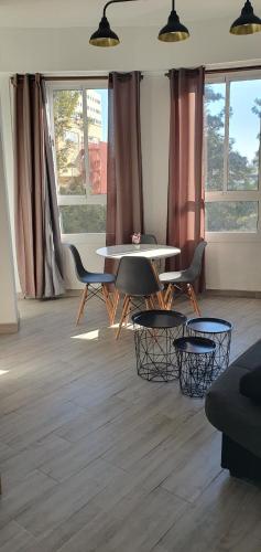 a living room with a table and chairs and windows at Flats Puente Ademuz Apartamento de 3 habitaciones in Valencia
