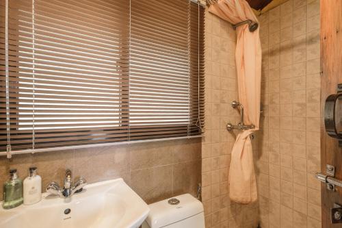 un bagno con lavandino, water e finestra di Shivapuri Heights Cottage a Kathmandu
