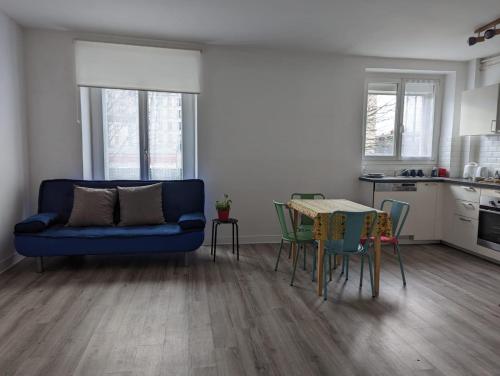 - un salon avec un canapé bleu et une table dans l'établissement ROSE, à Saint-Mandé
