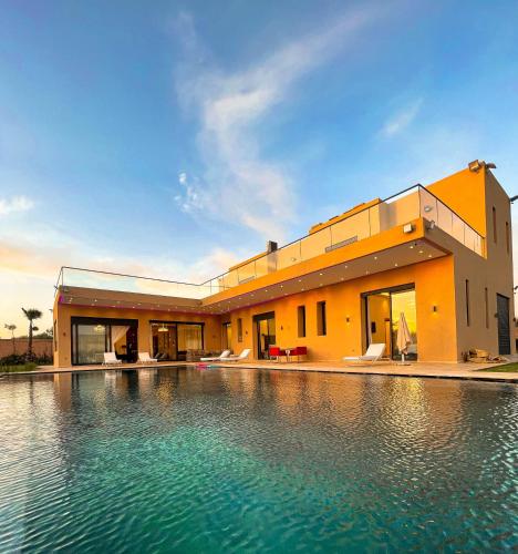 una casa con una piscina di fronte di Villa 7palms a Marrakech