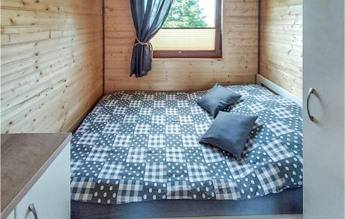 una camera con un letto in una cabina di legno di Cozy Home In Postomino With Outdoor Swimming Pool a Postomino